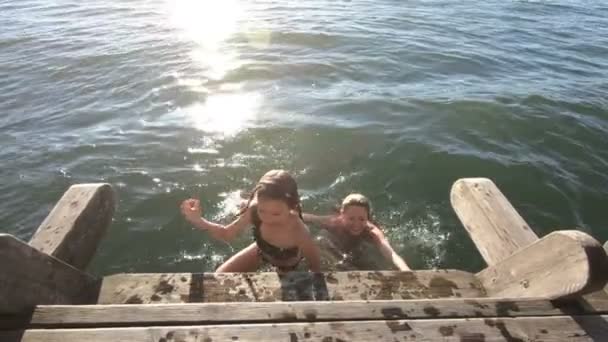 Маленькая стройная женщина с дочерью, купающаяся в озере — стоковое видео