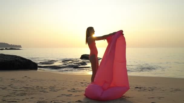 Una joven con sombrero de paja disfrutando de paz y privacidad al atardecer en la playa — Vídeos de Stock