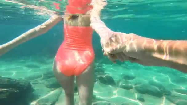 Folgen Sie mir. junge Frau führt Freund in türkisfarbenes Meer, Unterwasserfilm. — Stockvideo