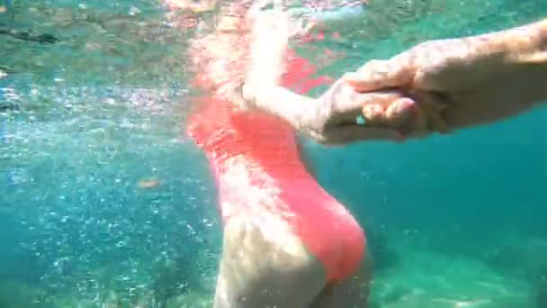Volg mij. jonge vrouw leiden vriend in turquoise zie water, onderwater film. — Stockvideo