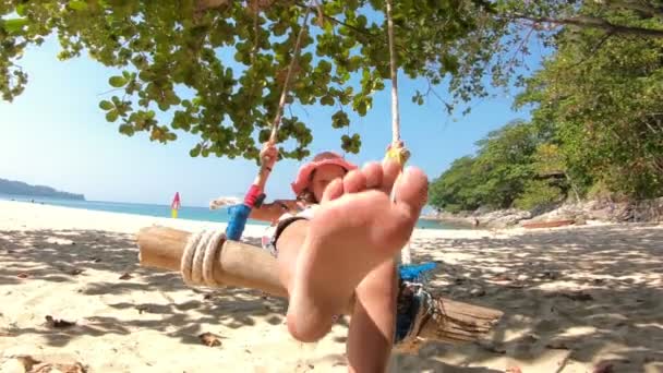 Kleines Mädchen schaukelt mit dem Meer im Hintergrund — Stockvideo