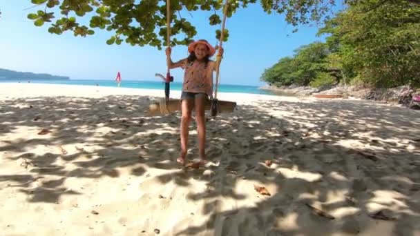 Kleines Mädchen schaukelt mit dem Meer im Hintergrund — Stockvideo