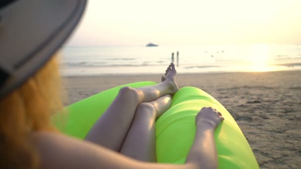 Młoda kobieta w słomkowym kapeluszu ciesząca się spokojem i prywatnością o zachodzie słońca na plaży — Wideo stockowe