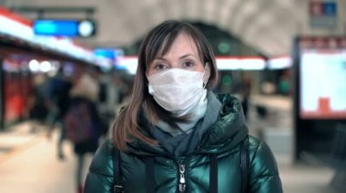 Young woman in protective sterile medical face mask on metro station