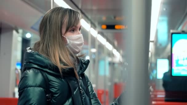 Mujer joven con mascarilla médica protectora en un vagón subterráneo — Vídeo de stock