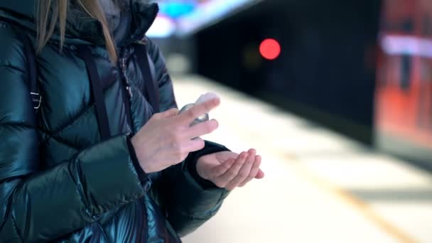 Uma jovem usa líquido higienizador de mão em uma estação de metrô — Vídeo de Stock