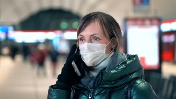 Mujer joven con mascarilla protectora estéril en una estación de metro — Vídeos de Stock