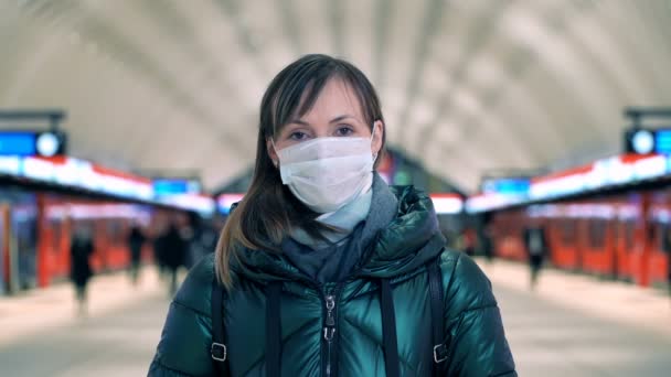 Young woman in protective sterile medical face mask on metro station — Stockvideo