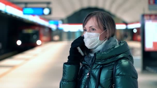 Mujer joven con mascarilla protectora estéril en una estación de metro — Vídeos de Stock