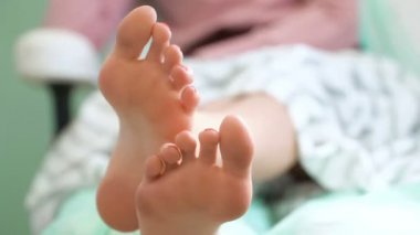 Pedikür salonunun tedavi odasında genç bir kadın. Ayaklara yakın çekim.