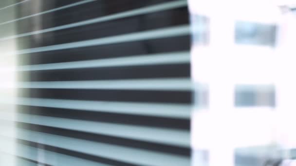 Сумна молода жінка в масці медичного захисту, яка дивиться у вікно — стокове відео