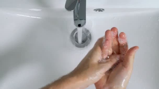 Genç adam banyoda ellerini yıkıyor. — Stok video