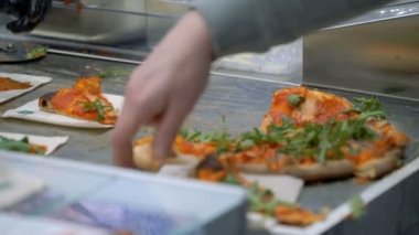 Bir şef ziyaretçilere pizza numuneleri dağıtır.