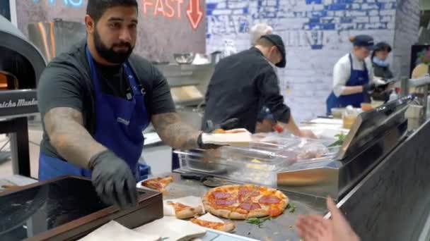 Un chef distribuye muestras de pizza a los visitantes — Vídeos de Stock