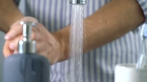 Чоловік середнього віку миє руки у ванній вдома — стокове відео