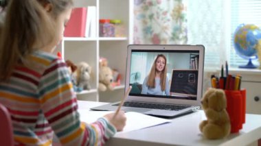 Genç bayan uzaktan öğretmen dizüstü bilgisayarla konferans veriyor. Öğrenciyle iletişim kuruyor.