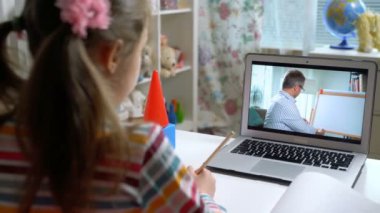 Orta yaşlı erkek mesafe öğretmeni bilgisayardaki konferansta öğrenciyle iletişim kuruyor.