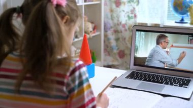 Orta yaşlı erkek mesafe öğretmeni bilgisayardaki konferansta öğrenciyle iletişim kuruyor.