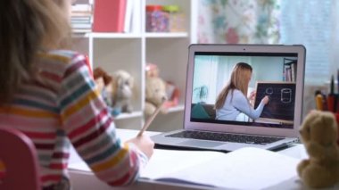 Genç bayan uzaktan öğretmen dizüstü bilgisayarla konferans veriyor. Öğrenciyle iletişim kuruyor.