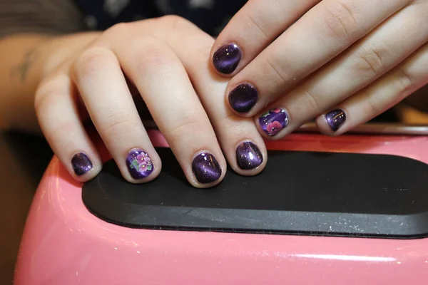 Diseño de manicura púrpura con un patrón de flores — Foto de Stock
