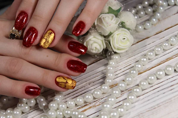 Manicured nails colored with red nail polish