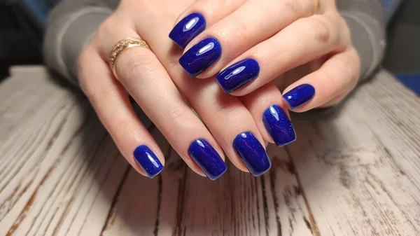 Closeup of hands of a young woman manicure on nails against white background — 스톡 사진