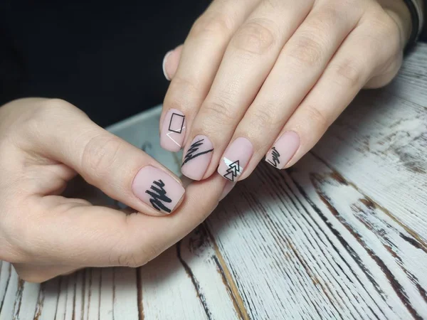 Sluiten van de handen van een jonge vrouw manicure op nagels tegen witte achtergrond — Stockfoto