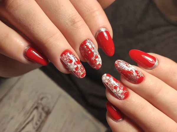 Rode kerstmanicure met herten en sneeuwvlokken — Stockfoto