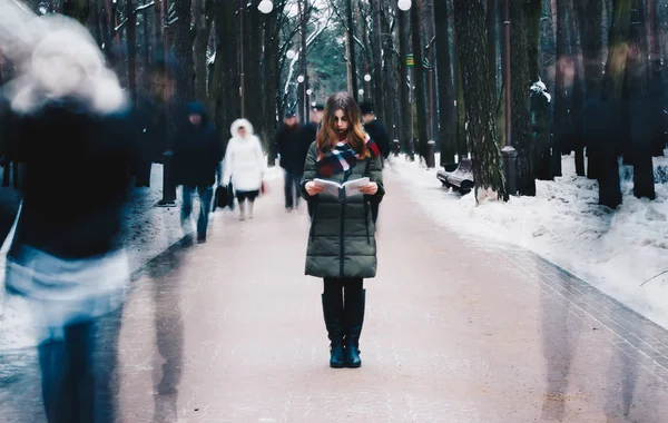 Portrait d'une belle jeune fille avec des lèvres rouges dans une veste, une écharpe attachée autour de son cou livre de lecture — Photo