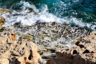 Deniz suyu dalgalar kayalar ve formlar bir köpük vurmak