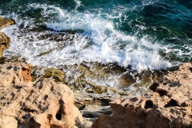 Deniz suyu dalgalar kayalar ve formlar bir köpük vurmak