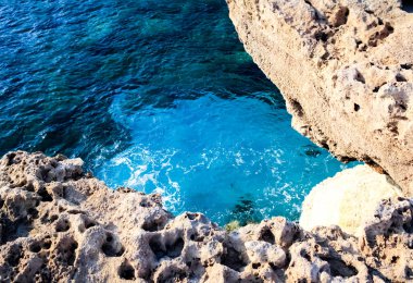 Deniz suyu dalgalar kayalar ve formlar bir köpük vurmak