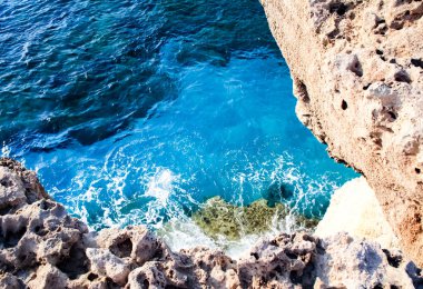 Deniz suyu dalgalar kayalar ve formlar bir köpük vurmak