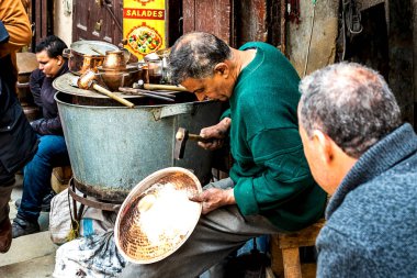 Fes, Fas, 21.04.2019: Fas 'taki Fes kentindeki bir pazarda tanımlanamayan insanlar geleneksel metal plaka yapıyorlar.