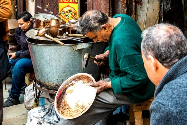 Fes, Fas, 21.04.2019: Fas 'taki Fes kentindeki bir pazarda tanımlanamayan insanlar geleneksel metal plaka yapıyorlar.