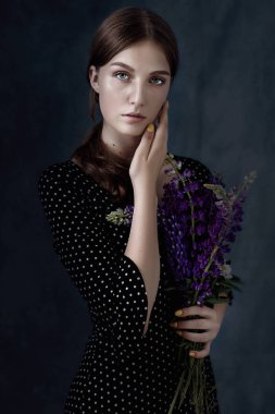 Stüdyo shot gri arka planda izole sarı saçlı güzel bir yalnız kız dramatik portresi