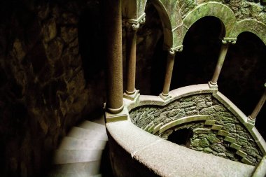 İçinde pencereler ve merdivenler olan bir kulenin güzel bir görüntüsü. Quinta da Regaleira kalesi, Monteiro Sarayı, Sintra, Portekiz