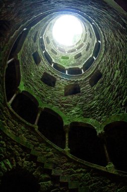 A beautiful image of the wall of a tower with windows and stairs from inside. Quinta da Regaleira castle, Monteiro Palace, Sintra, Portugal clipart