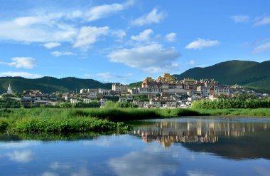 Songzanlin Tibetan Buddhist Monastery reflecting in the water of clipart