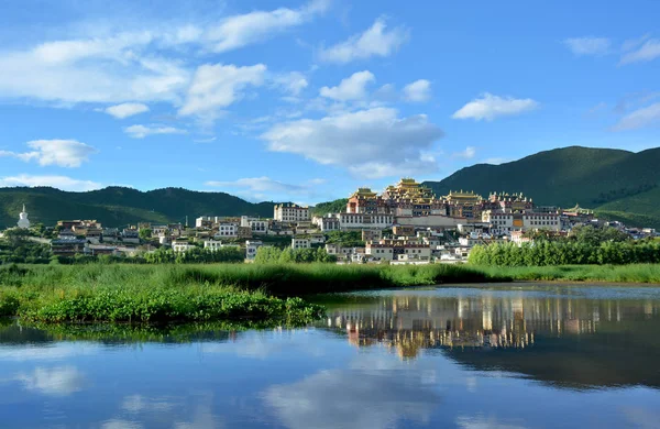 Songzanlin Mosteiro Budista Tibetano refletindo na água de — Fotografia de Stock