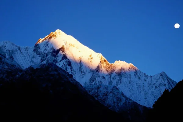 Mount lit by the rays of the rising sun. Sunrise in Himalayan mo