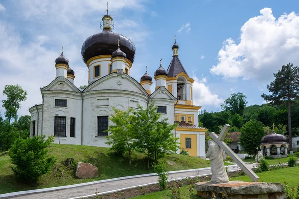 Ortodoxní klášter Condrita v Moldavsku. Socha Ježíše Krista nesoucího kříž na popředí — Stock fotografie