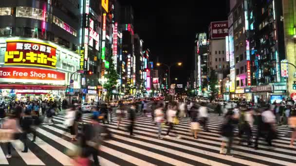 Tóquio - Vista noturna de rua com pessoas cruzando a rua em Shinjuku. lapso de tempo de resolução 4K — Vídeo de Stock