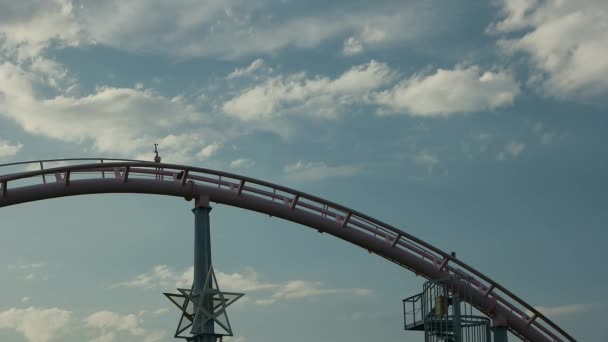 Yokohama - montanha-russa Desaparece andando contra o céu azul com nuvens em movimento rápido no Yokohama Cosmoworld. Resolução 4K acelera . — Vídeo de Stock