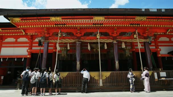 Kyoto - Visitantes en el santuario de Yasaka tirando de las cuerdas de las campanas sintoístas japonesas . — Vídeos de Stock