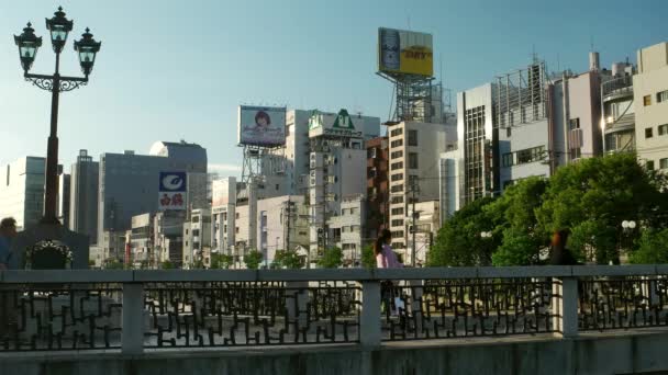 Fukuoka, insanlar akşam vakti köprüde yürüyorlar. 4K çözünürlüğü. — Stok video