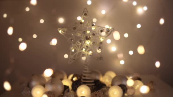 Fondo navideño con estrellas brillando en la oscuridad, nevando y luces desenfocadas en primer plano y fondo. Disparo a cámara lenta. Profundidad superficial del campo . — Vídeo de stock