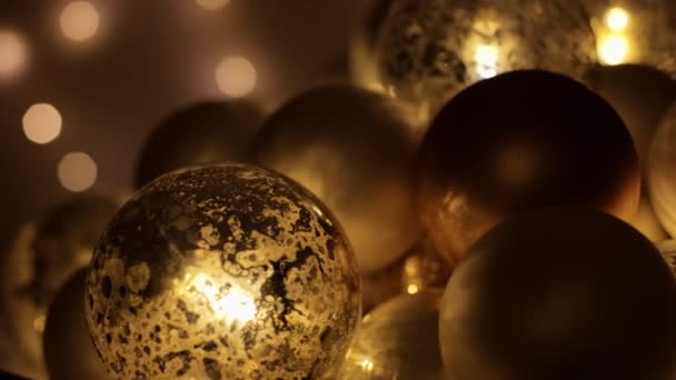 背景には焦点を絞ったライトで暗闇の中で輝くクリスマスの泡。4K解像度トラックショット. — ストック動画