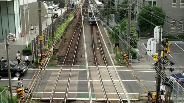 Tokio - Gente esperando en el cruce del ferrocarril mientras pasa el tren. Resolución 4K. Shinjuku. — Vídeos de Stock