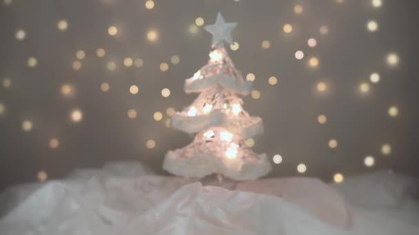 Albero di Natale luminoso su neve bianca con luci sfocate sullo sfondo. Risoluzione 4K tiro dolly. Profondità di campo ridotta . — Video Stock